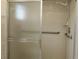 Bathroom with a shower equipped with safety features, including a grab bar and sliding glass doors at 9948 Se 175Th Pl, Summerfield, FL 34491