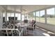 Bright sunroom with tile floors, ceiling fan, and many windows overlooking golf course at 9948 Se 175Th Pl, Summerfield, FL 34491