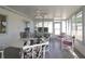 Bright sunroom featuring tile floors, ceiling fan, and white patio furniture at 9948 Se 175Th Pl, Summerfield, FL 34491