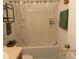 The shower and tub combo features a plastic curtain and shelving for storage at 1010 Chelsea Dr, Davenport, FL 33897