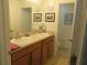 Bright bathroom featuring a double sink vanity with framed mirrors and tile flooring at 1010 Chelsea Dr, Davenport, FL 33897