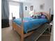 This bedroom has a bed with blue bedding, a dark dresser and a dog ramp at 1010 Chelsea Dr, Davenport, FL 33897