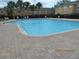 Large, sparkling community pool surrounded by lush landscaping and ample lounge seating at 1010 Chelsea Dr, Davenport, FL 33897