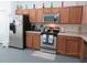 Functional kitchen equipped with stainless steel appliances, wooden cabinets, and ample counter space at 1010 Chelsea Dr, Davenport, FL 33897
