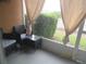 Private patio with stylish dark wicker furniture and tranquil views of lush greenery at 1010 Chelsea Dr, Davenport, FL 33897
