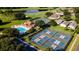 Aerial view showcasing the community pool, tennis courts, clubhouse, and lush green surroundings at 1022 Saint Ives Ct, Mount Dora, FL 32757