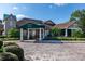 Clubhouse entrance featuring manicured landscaping, mature trees, and inviting covered entry at 1022 Saint Ives Ct, Mount Dora, FL 32757
