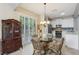 Dining room with sliding doors to the backyard, a glass table, and a cabinet for storage at 1022 Saint Ives Ct, Mount Dora, FL 32757