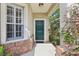 Close-up of the front door entrance showcasing brick accents and lush surrounding greenery at 1022 Saint Ives Ct, Mount Dora, FL 32757