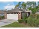 Charming single-Gathering home with brick facade, two-car garage, and landscaped front yard at 1022 Saint Ives Ct, Mount Dora, FL 32757
