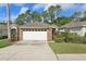 Brick home with a two car garage and mature landscaping at 1022 Saint Ives Ct, Mount Dora, FL 32757
