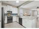 Bright kitchen boasts stainless steel appliances, white cabinetry, and a convenient breakfast bar overlooking the living area at 1022 Saint Ives Ct, Mount Dora, FL 32757