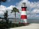 Scenic lighthouse by the water featuring red and white stripes, blue skies, and water views at 1022 Saint Ives Ct, Mount Dora, FL 32757
