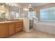 Bathroom with a shower and soaking tub, a window with blinds, and vanity at 10257 Dovehill Ln, Clermont, FL 34711