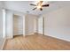 Bedroom with a ceiling fan, closet with open doors, and wood-look tile floor at 10257 Dovehill Ln, Clermont, FL 34711