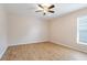 Spacious bedroom featuring wood-look tile floor, ceiling fan, and a window at 10257 Dovehill Ln, Clermont, FL 34711