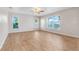 Bright bedroom featuring wood-look tile floors, a ceiling fan, and multiple windows offering natural light at 10257 Dovehill Ln, Clermont, FL 34711