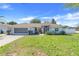 Beautiful single-story home with a lush green lawn, screened garage, and well-maintained landscaping at 10257 Dovehill Ln, Clermont, FL 34711