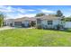 Charming single-story home with a well-manicured lawn, beautiful landscaping, and an attached two-car garage at 10257 Dovehill Ln, Clermont, FL 34711