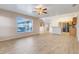 Spacious living room featuring tile floors, a ceiling fan, and a view into the open kitchen area at 10257 Dovehill Ln, Clermont, FL 34711