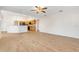 Open-concept living area showcasing tile floors, a ceiling fan, and a view into the adjacent kitchen area at 10257 Dovehill Ln, Clermont, FL 34711