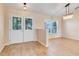 Bright living room featuring double doors, wood floors, and chandelier at 10257 Dovehill Ln, Clermont, FL 34711