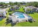 Aerial view of the community pool, clubhouse, and surrounding townhomes nestled in a green landscape at 1051 S Highland St # 4B, Mount Dora, FL 32757