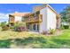 Exterior view of a well-maintained two-story townhome with a balcony overlooking the landscaped backyard at 1051 S Highland St # 4B, Mount Dora, FL 32757