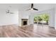 Well-lit living room with wood floors, brick fireplace, ceiling fan, and sliding glass doors at 1051 S Highland St # 4B, Mount Dora, FL 32757