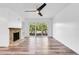 Bright living room featuring wood floors, a stone fireplace, ceiling fan, and sliding glass doors at 1051 S Highland St # 4B, Mount Dora, FL 32757