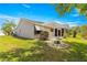 Beautiful backyard featuring a covered patio, lush lawn, and mature landscaping, ideal for outdoor enjoyment at 1089 Nash Loop, The Villages, FL 32162