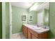 Bathroom featuring a double sink vanity with wood cabinets and a large mirror at 1089 Nash Loop, The Villages, FL 32162