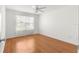 Bright bedroom featuring laminate wood flooring, a ceiling fan, and a window at 1089 Nash Loop, The Villages, FL 32162