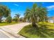 Well maintained home featuring lush green lawn, mature trees, and a uniquely patterned driveway at 1089 Nash Loop, The Villages, FL 32162