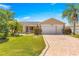 Charming single-story home featuring a two-car garage, screened in porch and tropical landscaping at 1089 Nash Loop, The Villages, FL 32162