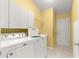 Bright laundry room featuring a washer, dryer, sink, and storage at 1089 Nash Loop, The Villages, FL 32162