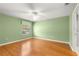 Spacious main bedroom with wood flooring, ceiling fan, and large window for natural light at 1089 Nash Loop, The Villages, FL 32162