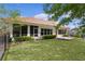 Charming home featuring a serene backyard with lush green grass, mature landscaping, and screened-in porch perfect for enjoying outdoors at 11497 Sw 82Nd Court Rd, Ocala, FL 34481