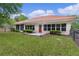 Spacious backyard with lush green lawn, garden, patio and exterior view of the house at 11497 Sw 82Nd Court Rd, Ocala, FL 34481