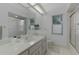 Well-lit bathroom with dual windows, shower, and a neutral colored countertop and cabinets at 11497 Sw 82Nd Court Rd, Ocala, FL 34481