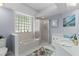 Well-lit bathroom features a garden tub, a glass enclosed shower, and a vanity with ample counter space at 11497 Sw 82Nd Court Rd, Ocala, FL 34481