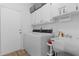 Functional laundry room equipped with a washer, dryer, utility sink, and storage cabinets at 11497 Sw 82Nd Court Rd, Ocala, FL 34481