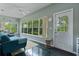 Bright sunroom with large windows, ceiling fan, comfortable seating, and stylish decor at 11497 Sw 82Nd Court Rd, Ocala, FL 34481