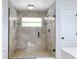 Renovated bathroom featuring a frameless glass shower and neutral-toned tile at 11763 Oswalt Rd, Clermont, FL 34711