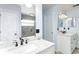 Bathroom with dual sinks, framed mirrors, and a tiled shower enclosure at 11763 Oswalt Rd, Clermont, FL 34711