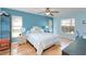 Comfortable bedroom with light-blue walls, ceiling fan, and natural lighting from windows at 11763 Oswalt Rd, Clermont, FL 34711