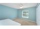 Minimalist bedroom with a large window, soft carpet, and plenty of natural light at 11763 Oswalt Rd, Clermont, FL 34711