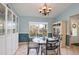 Bright dining room features a glass table, stylish chandelier, and beautiful display cabinets at 11763 Oswalt Rd, Clermont, FL 34711