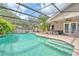 Beautiful screened-in pool with spa, sun shelf and well-maintained landscaping at 11763 Oswalt Rd, Clermont, FL 34711