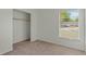 Cozy bedroom with natural light, carpet, and a closet providing a neutral and comfortable space at 11987 Se 95Th Ter, Belleview, FL 34420